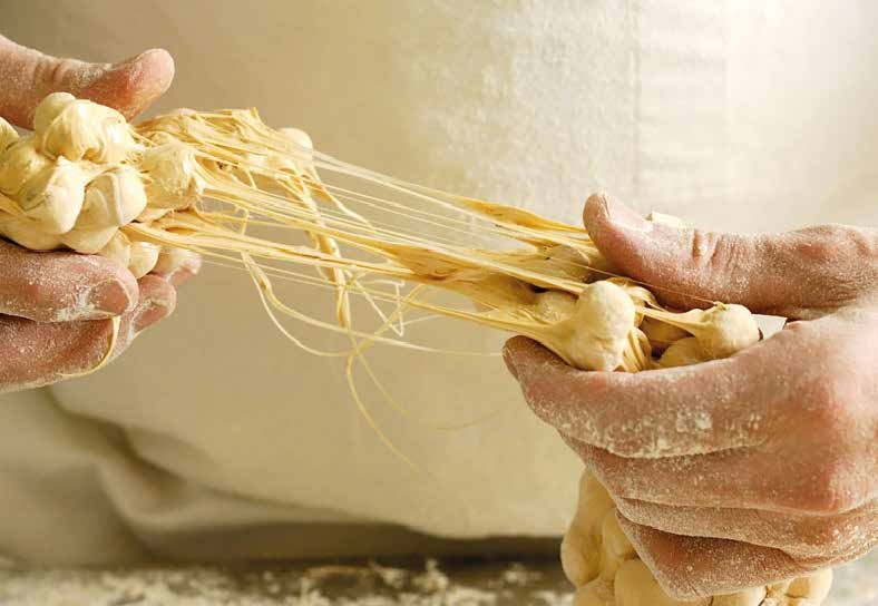 Manos amasando masa artesana